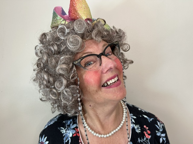 Live portrait of Grammy Z smiling in a colorful party hat